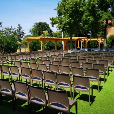 allestimento-all-aperto-con-numerose-sedie-disposte-in-file-ordinate-su-un-prato