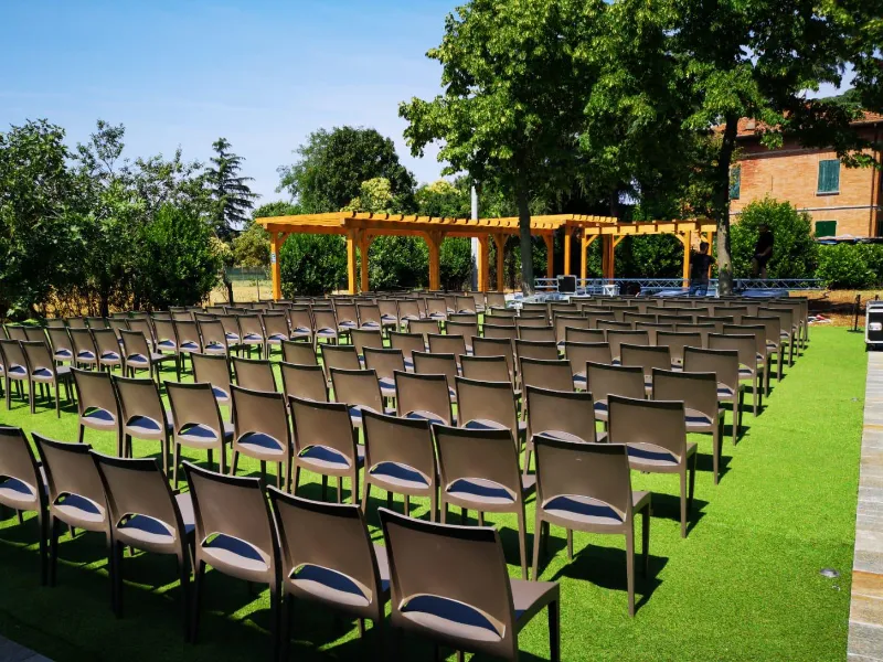 allestimento-all-aperto-con-numerose-sedie-disposte-in-file-ordinate-su-un-prato