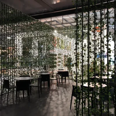 divisori-modulari-ricoperti-di-piante-rampicanti-attorno-alla-zona-bar-con-tavoli-e-sedie-neri