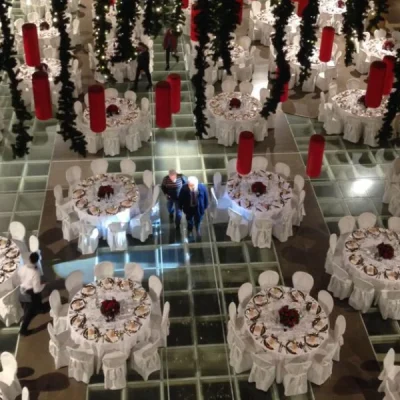 sala-elegante-allestita-a-tema-natalizio-con-tavoli-tondi-tovaglie-bianche-e-decorazioni-rosse