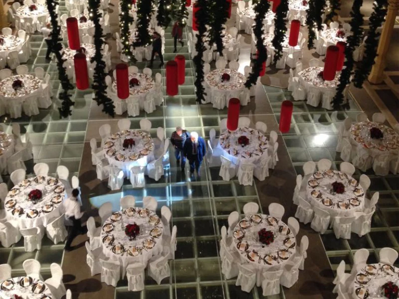 sala-elegante-allestita-a-tema-natalizio-con-tavoli-tondi-tovaglie-bianche-e-decorazioni-rosse