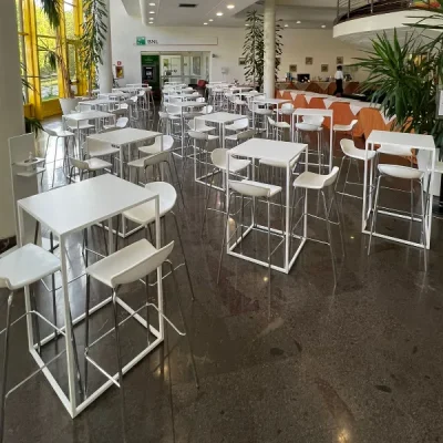 sala-moderna-con-dettagli-gialli-e-piante-arredata-con-tavoli-modello-square-bianchi-e-sedute-abbinate