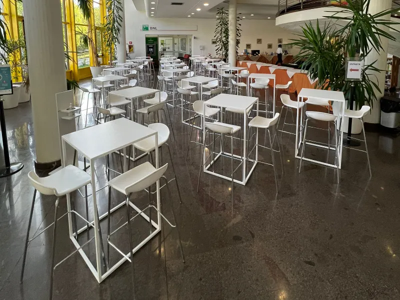 sala-moderna-con-dettagli-gialli-e-piante-arredata-con-tavoli-modello-square-bianchi-e-sedute-abbinate