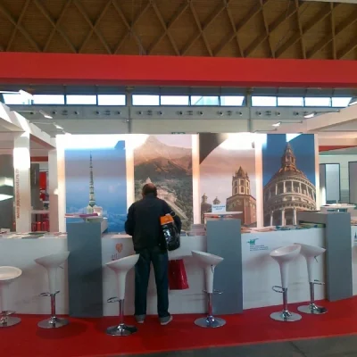 stand-con-bancone-bianco-illustrazioni-delle-citta-italiane-tappeto-rosso-e-sgabelli-bianchi-modello-bombo